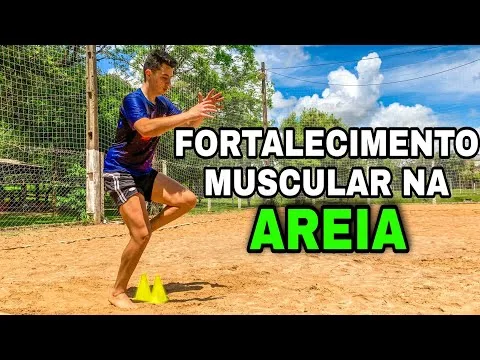 Pessoa realizando exercício de fortalecimento muscular em quadra de areia, próximo a cones amarelos, com fundo de árvores e céu azul.
