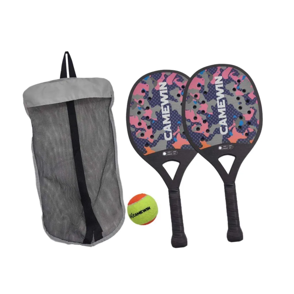 Kit de frescobol CAMEWIN com duas raquetes coloridas em padrão camuflado, bola amarela e vermelha e bolsa de transporte em rede sobre a areia.