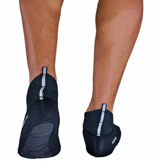 Pessoa usando calçado esportivo preto tipo meia de neoprene com sola antiderrapante, ideal para beach tennis e atividades aquáticas.