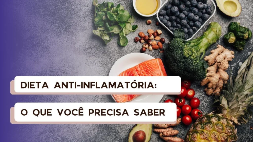 Prato com salmão, abacate, brócolis, mirtilos, tomate, gengibre, abacaxi, folhas verdes, oleaginosas e azeite sobre superfície cinza, representando alimentos típicos de uma dieta anti-inflamatória.