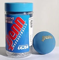 Embalagem transparente com tampa azul contendo bolas Penn de racquetball, acompanhada de uma bola azul ao lado com o logotipo dourado “Penn”. O rótulo azul e vermelho exibe o texto “America’s #1 Selling Ball” e “Official Ball USRA”.