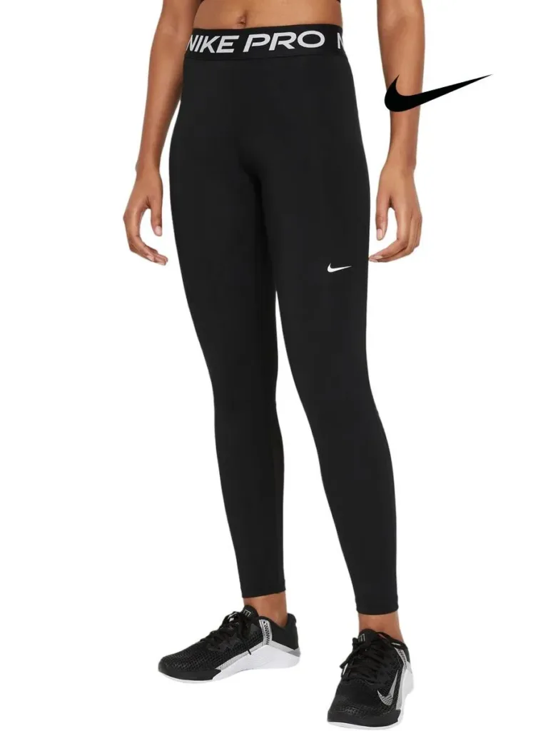 Mulher vestindo legging preta Nike Pro com cintura alta e logo branco da Nike, combinada com tênis esportivos pretos e brancos, ideal para treinos e esportes de alto desempenho.