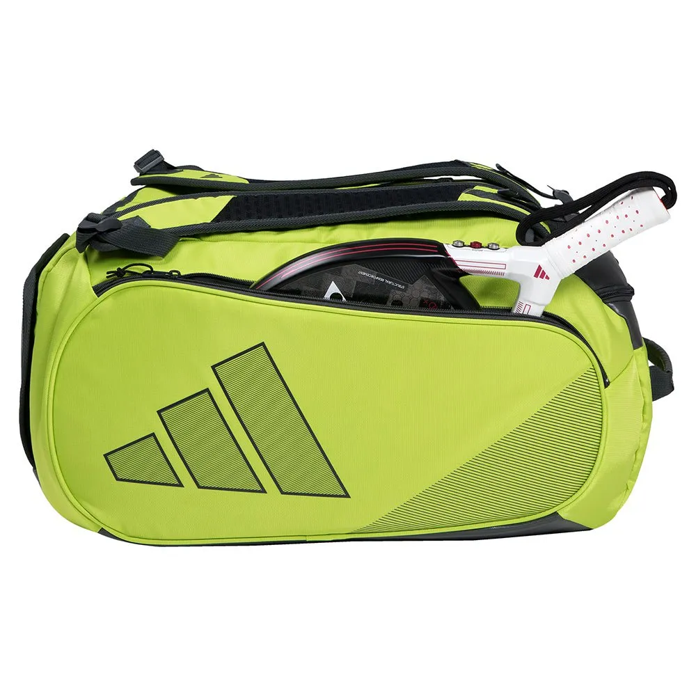 Bolsa Adidas Beach Tennis Bag na cor verde-limão com detalhes em preto, vista de lado sobre fundo branco. O compartimento lateral está aberto, mostrando uma raquete de beach tennis com cabo branco e detalhes vermelhos.