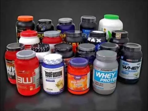 Diversos potes de suplementos proteicos organizados sobre superfície escura, com rótulos de marcas variadas como whey protein e IsoFusion.