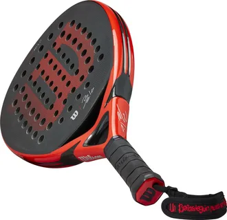 Raquete de beach tennis Wilson Bela Pro preta e vermelha, com logo “W” em destaque, assinatura do jogador Fernando Belasteguin e alça com frase bordada em vermelho.